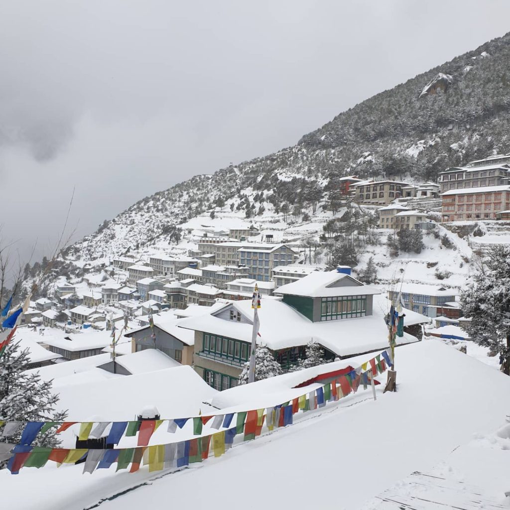 Namche Bazaar under fresh snow with prayer flags