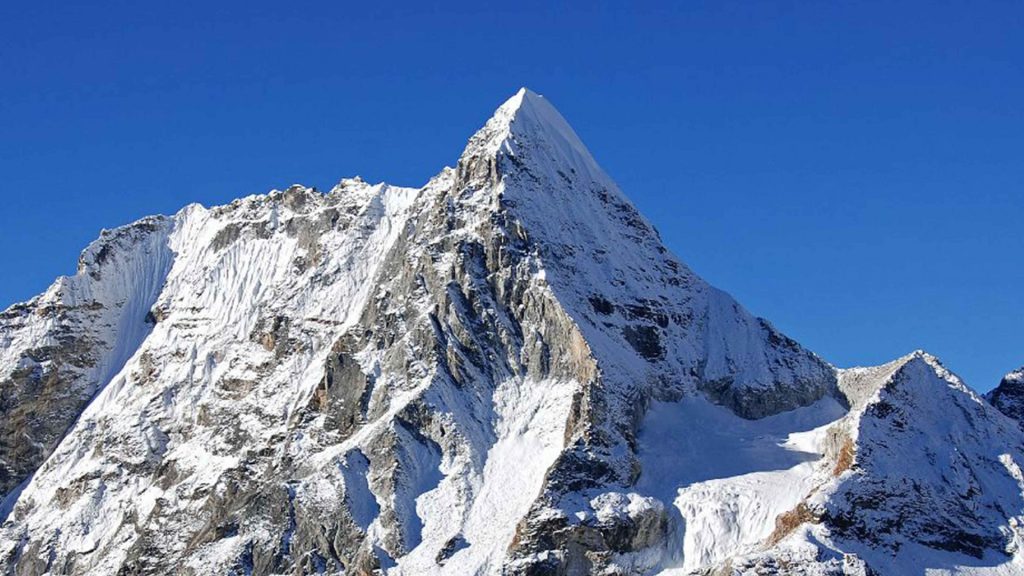 Steep snow pyramid in the Everest region under a blue sky