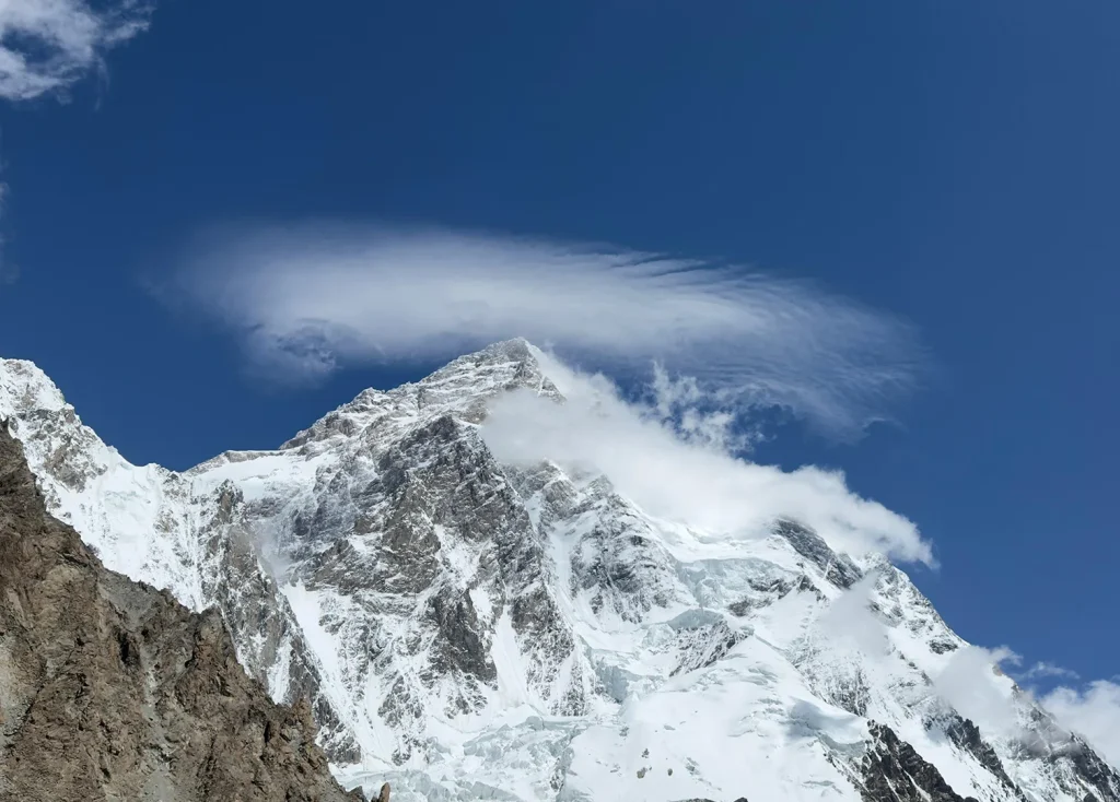 Snow-covered Karakoram peak under a lenticular cloud