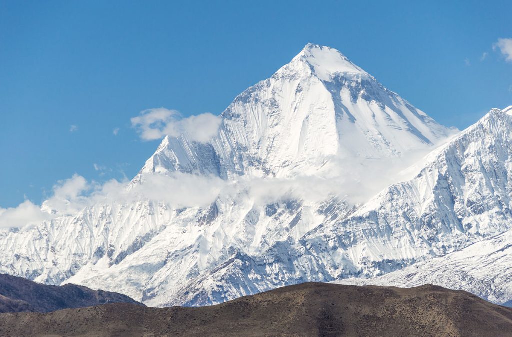 Dhaulagiri I under a blue sky with snowfields below