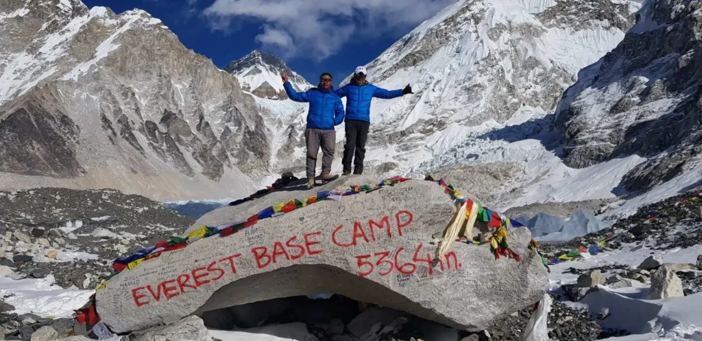 Trekkers on the Everest Base Camp rock at 5,364 m with the Khumbu Icefall behind
