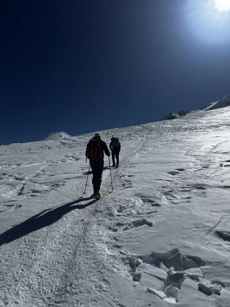 Two climbers walking up the Mera glacier in bright sun