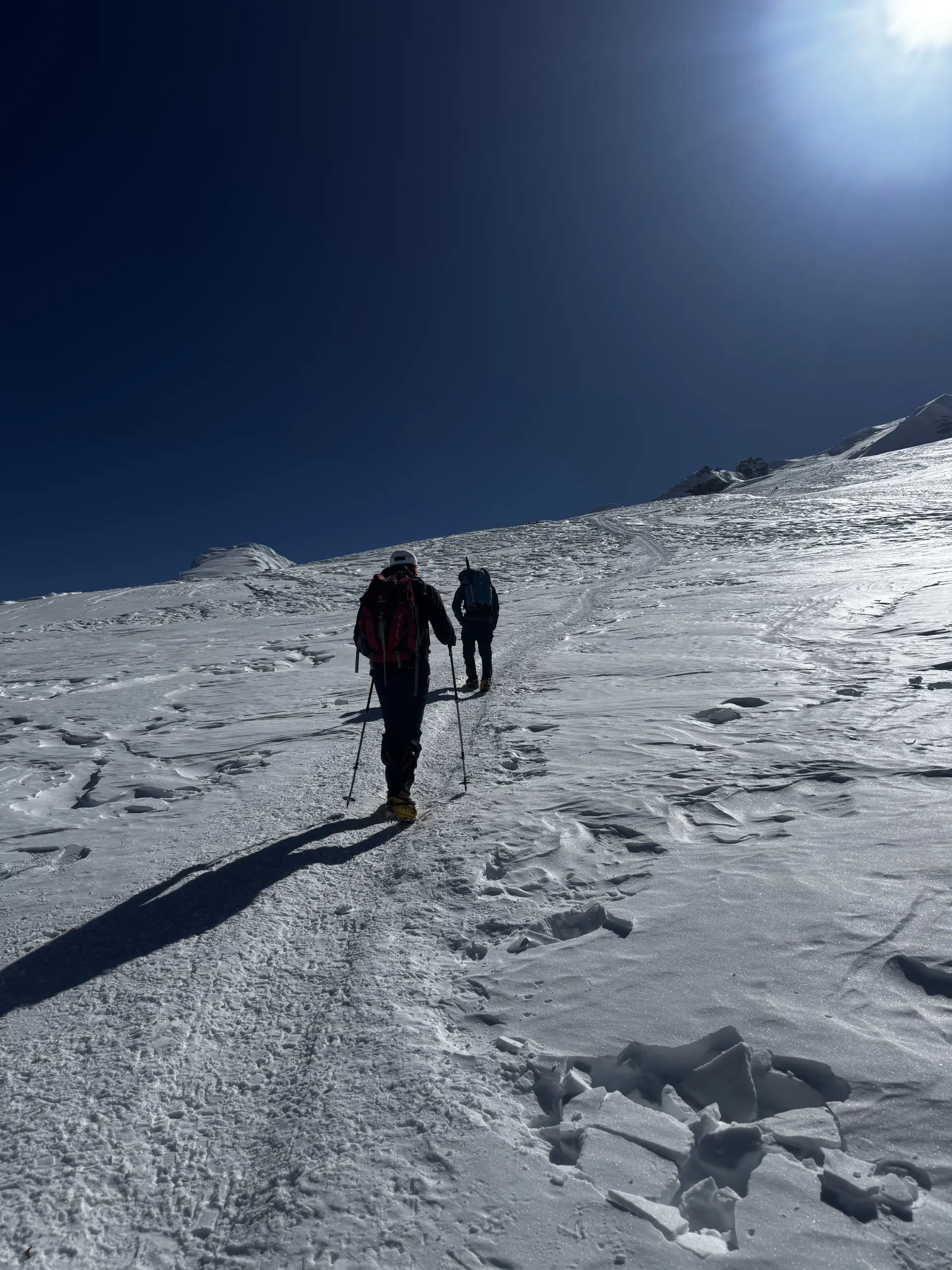 Two climbers walking up the Mera glacier in bright sun