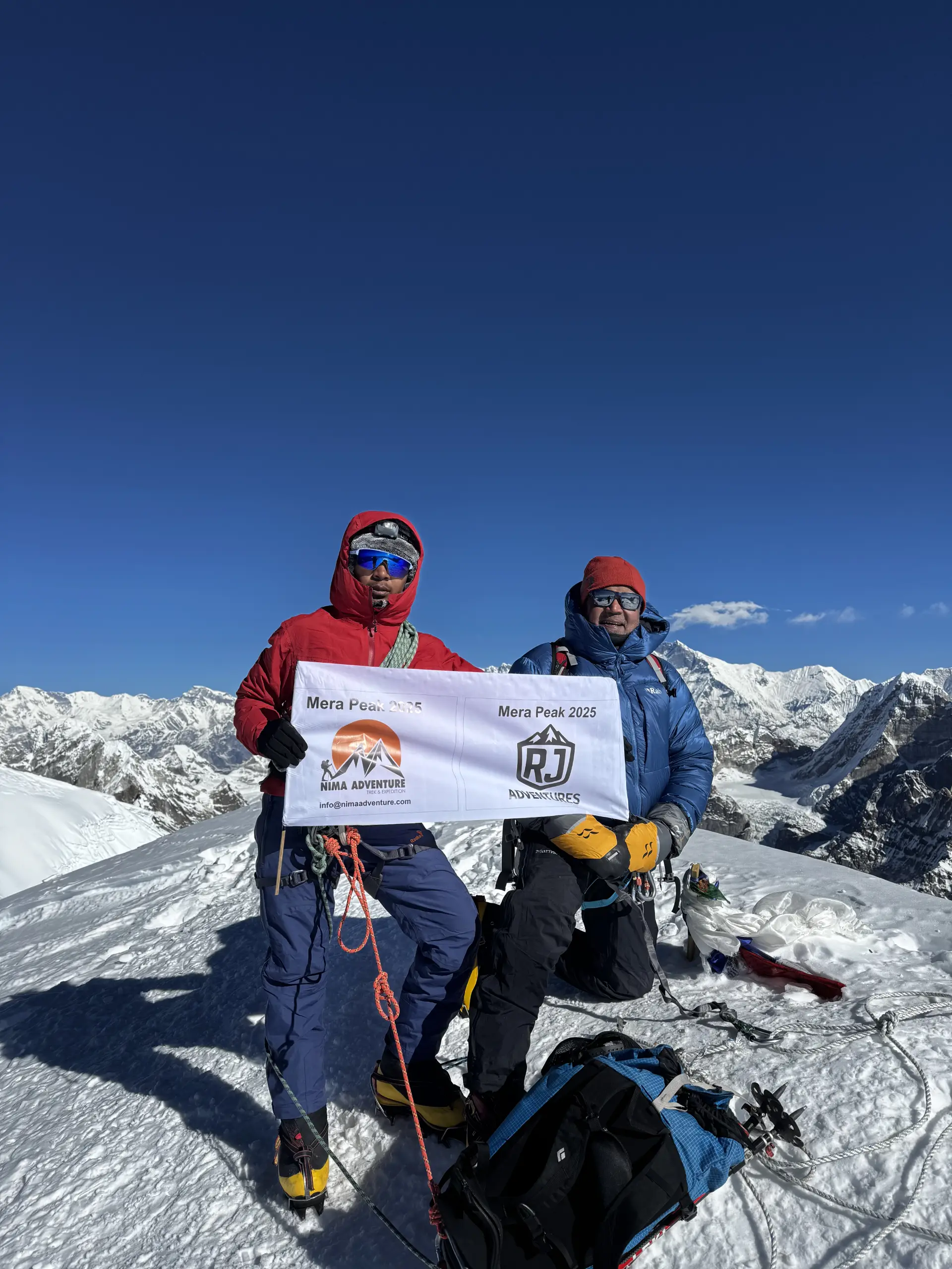 Climbers with a Nima Adventure banner on the Mera Peak summit