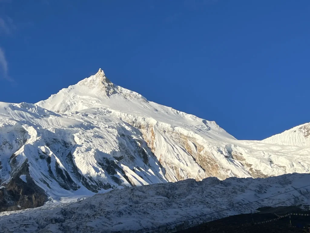 Manaslu summit pyramid under a deep blue sky
