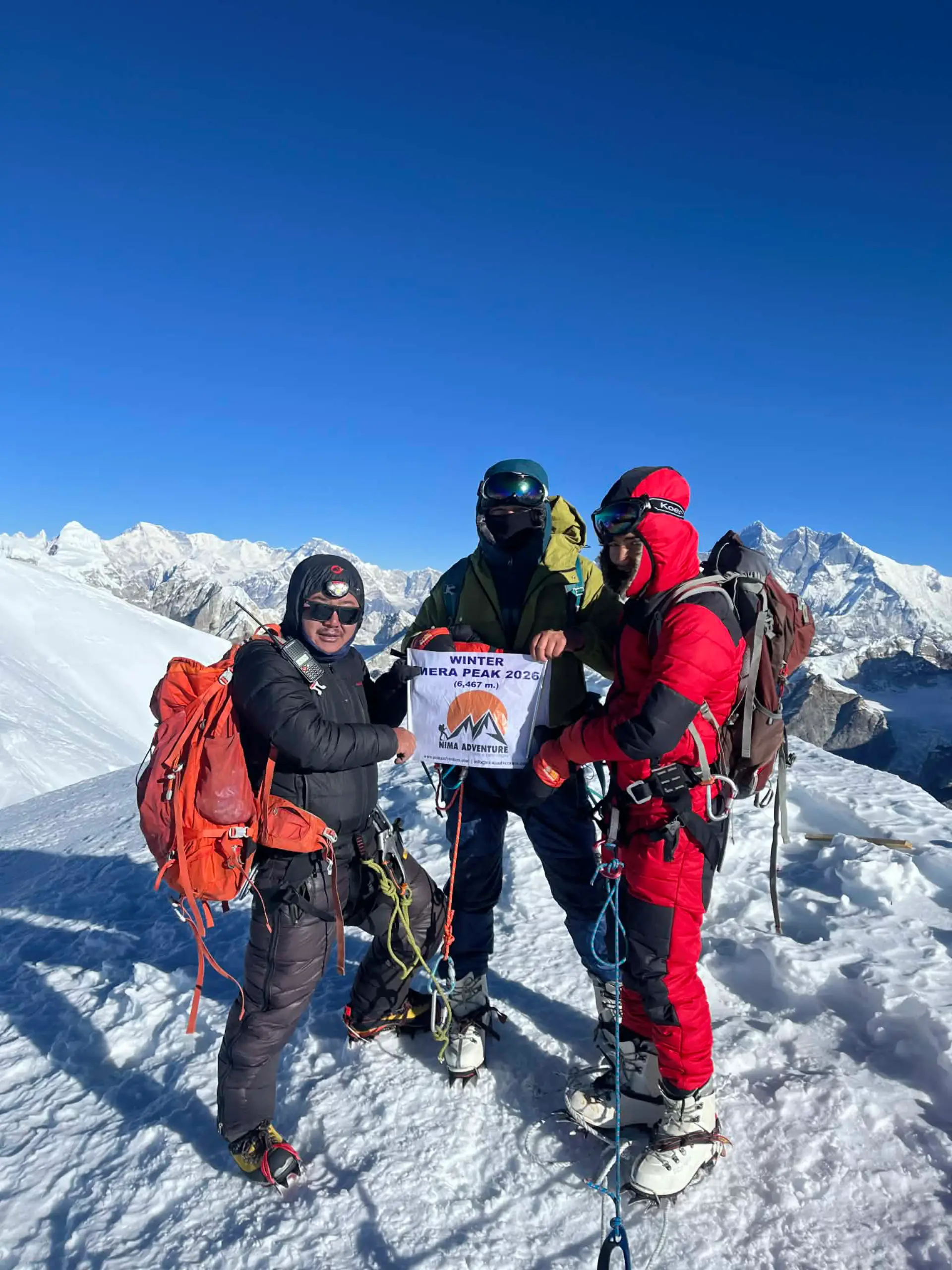 Climbing team holding a Nima Adventure banner on Mera Peak