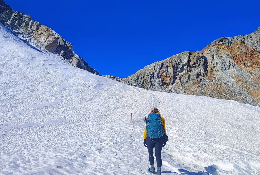 Trekker crossing a snowfield on a high pass in the Everest region