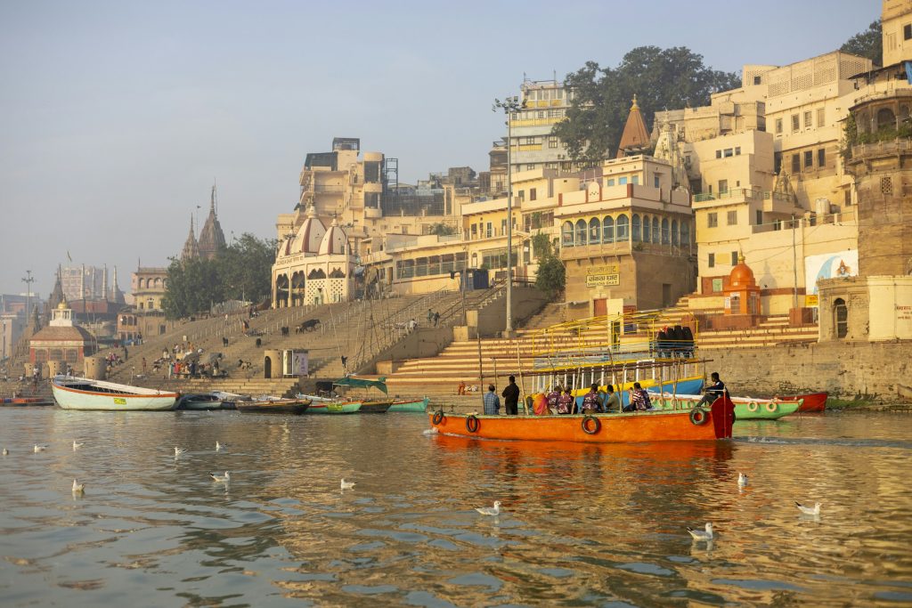 Boats on the Ganges in front of the stepped ghats and old riverside buildings of Varanasi