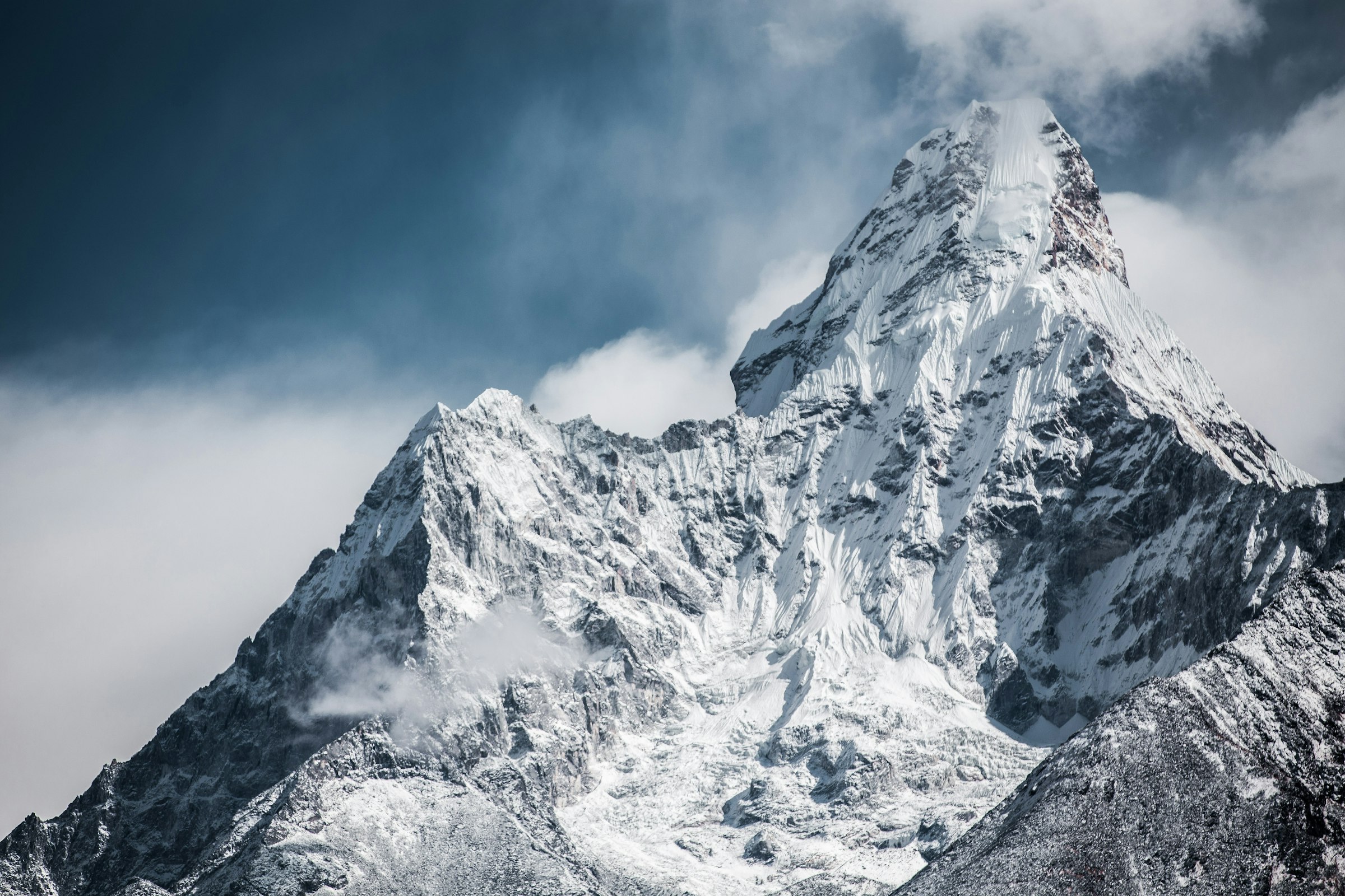 Snow-plastered Ama Dablam with its distinctive ridges and hanging glacier amid drifting cloud