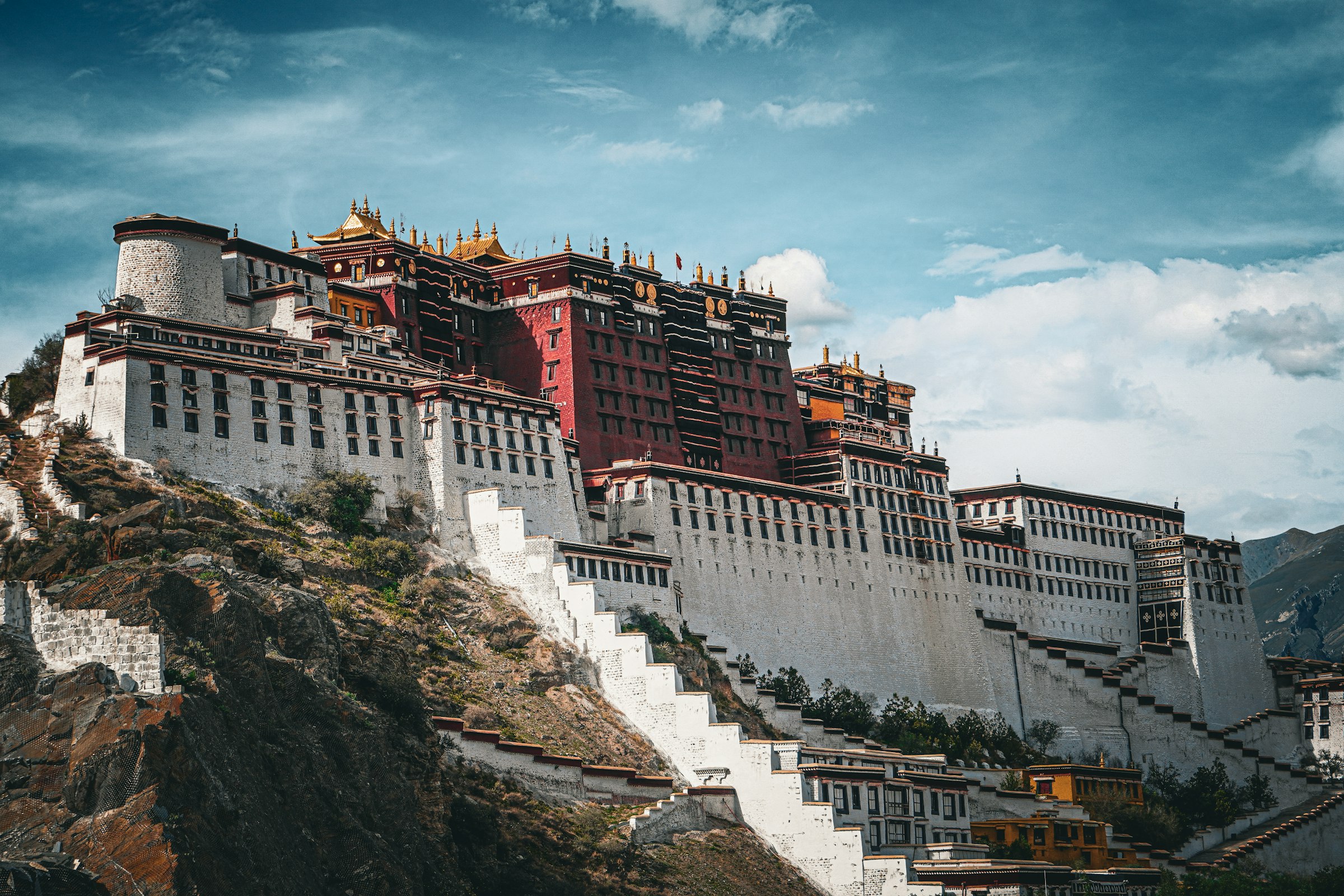 Potala Palace with its white and red walls and long stairways on its hill in Lhasa