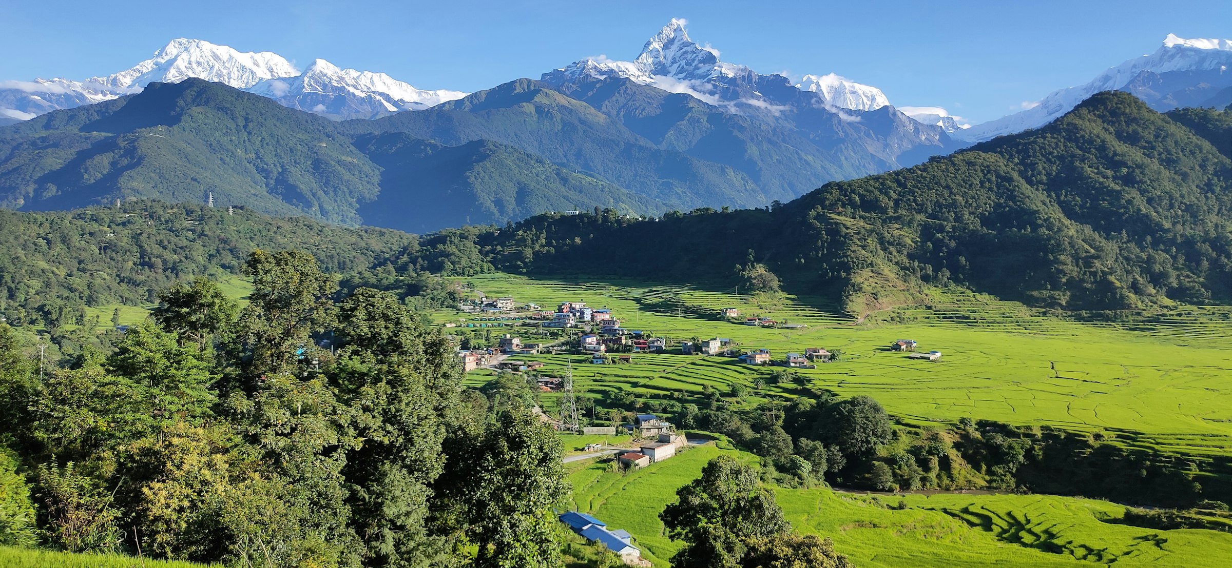 Green valley of farm terraces and villages below the Annapurna range and Machhapuchhre near Pokhara